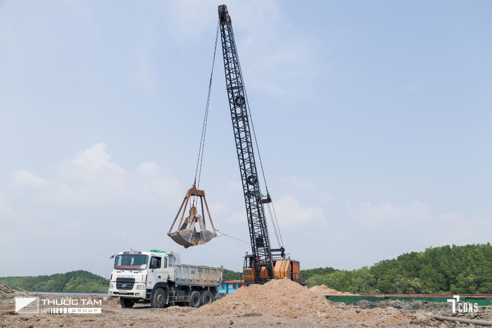 Trung chuyển vật liệu tại bến thủy, phối hợp cẩu và xe theo đúng trình tự vận hành.